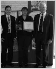 Three adults, one holding a certificate