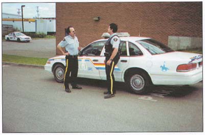 picture of two RCMP officers standing by a patrol car
