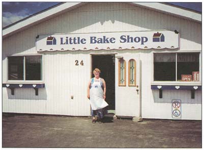 picture of a woman standing in front of a bakery shop