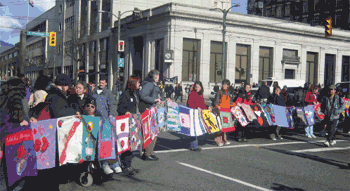 A crowd holding quilts