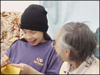 photo of an Aboriginal elder doing crafts with child