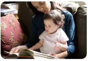 mother sitting with baby and a book