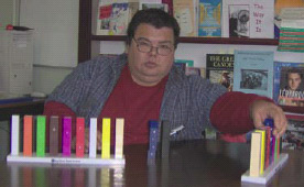 A person sitting at a table with examples of commercical manipulatives on it.