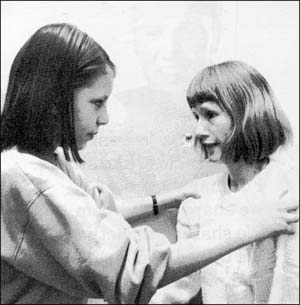 Girl holding another girl's shoulders