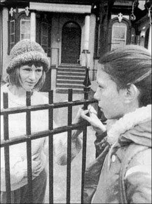 Two girls on opposite sides of a gate