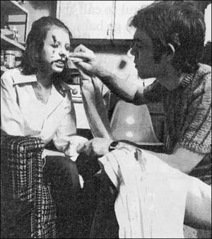 Man wiping blood off woman's face