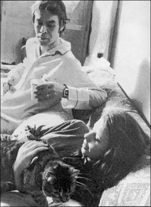 woman holding cat in bed