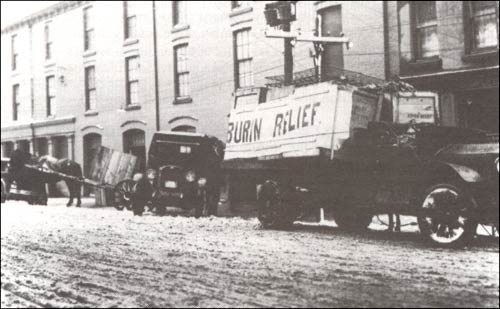 photo of vehicles; one has sign Burin Relief