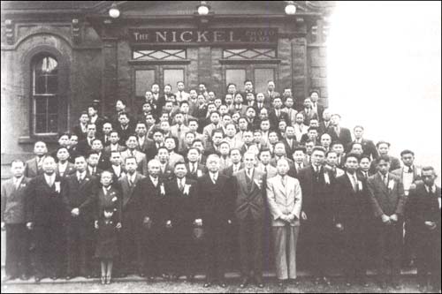 photo of a large group of people posed in front of a building