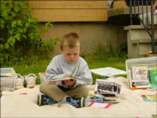Child sitting cross-legged and reading a book