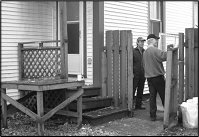 two men inspecting a fence