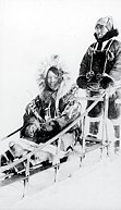 A man and woman riding a dog slide