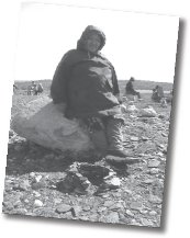 An Inuit laying on a rock