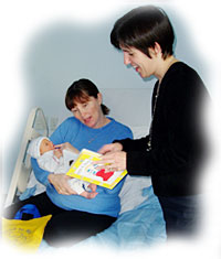 photo of a Family Literacy Practitioner showing a Read to Me! kit to a new mother at the hospital