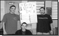 Graphic: a photograph of 3 people holding a sign
