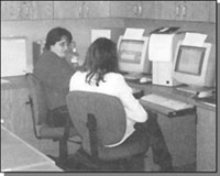 Graphic: a photograph of 2 women sitting in front of 2 computers (Ann McCann and Sonya Foley)