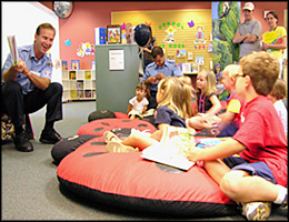 photo of a fireman reading to children