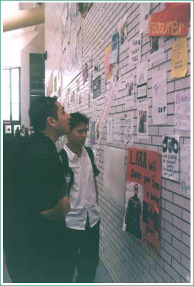 2 young men reading posters on the wall