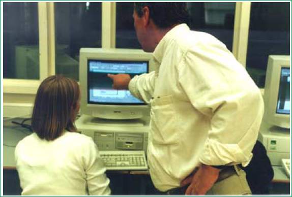 Man helping a woman at a computer