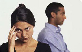 a frustrated woman in the foreground with a man in the background facing away from her.