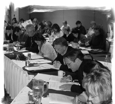 A group of people working side by side at long tables.