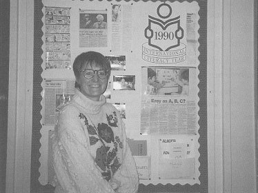 Pat beside her bulletin board