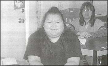 photo of two females sitting at their desks
