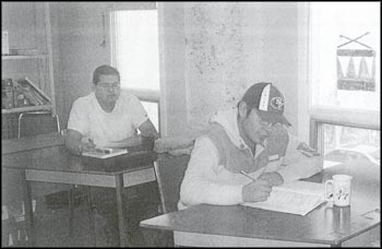 photo of two males in a classroom sitting at desks